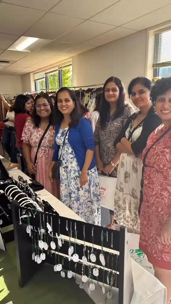 A group beside a jewellery display table at an indoor event